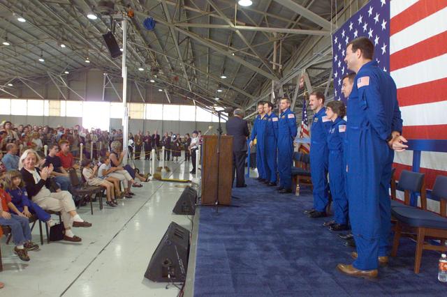 Photographic documentation of the STS-109 Crew Return Ceremony.  The events take place at Hangar 990 at Ellington Field.    Views include:  Overall view of crewmembers [09319]; View of crewmembers standing on stage talking to group [09320]; Unidentified crewmember waving to crowd [09321]; Unidentified crewmember autographing photo [09322];   Mission Specialist Michael J. Massimino holding crew photo as he talks to child in group [09323]; Pilot Duane G. Carey signing a crew photo for a visitor [09324];   Unidentified crewmember signing a photo for visitor [09325]; Commander Scott D. Altman talking to child in group [09326]; Unidentified crewmember giving a photo to visitor [09327]; Crewmembers exiting plane [09328]; Duane G. Carey shaking hands with visitor.  Astronaut Scott Altman smiling in the background [09329); Astronaut Jim Newman kissing his child [09330]; Jim Newman holding his daughter as his son grabs at his pant leg [09331]; Close-up view of Payload Commander John Grunsfeld holding his daughter [09332]; Duane G. Carey standing with family members [09333]; Close-up view of Duane G. Carey placing his hand on a child's head as he is talking to him [09334]; Overall view of spectator watching ceremony [09335]; Close-up view of speaker during ceremony [09336]; Close-up view of Scott Altman speaking to crowd [09337]; Close-up view of a young spectator at ceremony [09338]; Close-up view of Duane G. Carey speaking to the crowd [09339]; Close-up view of Mission Specialist Nancy J. Currie speaking to the crowd [09340]; Close-up view of John M. Grunsfield speaking to the crowd [09341]; Close-up view of Mission Specialist Richard M. Linnehan speaking to the crowd [09342]; Close-up view of James H. Newman speaking to the crowd [09343]; Close-up view of Michael J. Massimino speaking to the crowd [09344]