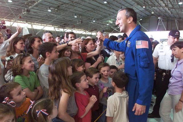 JSC2002-E-09321 (13 March 2002) --- Astronaut Michael J. Massimino, STS-109 mission specialist, greets the assembled crowd in Hangar 990 at Ellington Field during the crew return ceremonies.