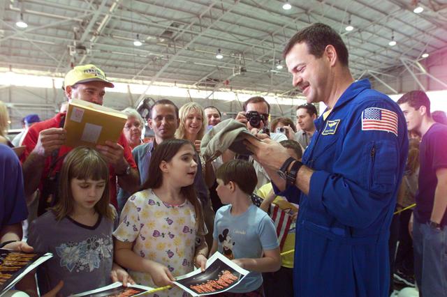 Photographic documentation of the STS-109 Crew Return Ceremony.  The events take place at Hangar 990 at Ellington Field.    Views include:  Overall view of crewmembers [09319]; View of crewmembers standing on stage talking to group [09320]; Unidentified crewmember waving to crowd [09321]; Unidentified crewmember autographing photo [09322];   Mission Specialist Michael J. Massimino holding crew photo as he talks to child in group [09323]; Pilot Duane G. Carey signing a crew photo for a visitor [09324];   Unidentified crewmember signing a photo for visitor [09325]; Commander Scott D. Altman talking to child in group [09326]; Unidentified crewmember giving a photo to visitor [09327]; Crewmembers exiting plane [09328]; Duane G. Carey shaking hands with visitor.  Astronaut Scott Altman smiling in the background [09329); Astronaut Jim Newman kissing his child [09330]; Jim Newman holding his daughter as his son grabs at his pant leg [09331]; Close-up view of Payload Commander John Grunsfeld holding his daughter [09332]; Duane G. Carey standing with family members [09333]; Close-up view of Duane G. Carey placing his hand on a child's head as he is talking to him [09334]; Overall view of spectator watching ceremony [09335]; Close-up view of speaker during ceremony [09336]; Close-up view of Scott Altman speaking to crowd [09337]; Close-up view of a young spectator at ceremony [09338]; Close-up view of Duane G. Carey speaking to the crowd [09339]; Close-up view of Mission Specialist Nancy J. Currie speaking to the crowd [09340]; Close-up view of John M. Grunsfield speaking to the crowd [09341]; Close-up view of Mission Specialist Richard M. Linnehan speaking to the crowd [09342]; Close-up view of James H. Newman speaking to the crowd [09343]; Close-up view of Michael J. Massimino speaking to the crowd [09344]