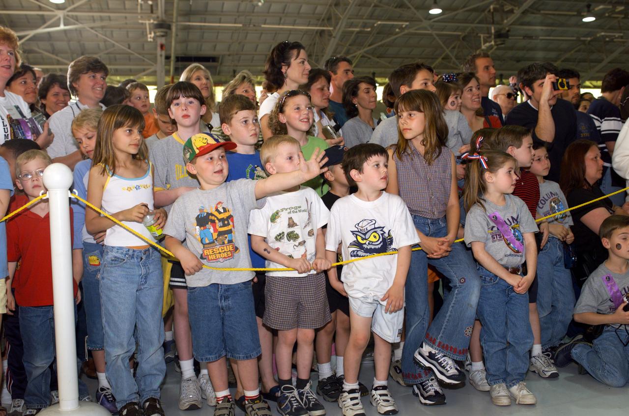 Photographic documentation of the STS-109 Crew Return Ceremony.  The events take place at Hangar 990 at Ellington Field.    Views include:  Overall view of crewmembers [09319]; View of crewmembers standing on stage talking to group [09320]; Unidentified crewmember waving to crowd [09321]; Unidentified crewmember autographing photo [09322];   Mission Specialist Michael J. Massimino holding crew photo as he talks to child in group [09323]; Pilot Duane G. Carey signing a crew photo for a visitor [09324];   Unidentified crewmember signing a photo for visitor [09325]; Commander Scott D. Altman talking to child in group [09326]; Unidentified crewmember giving a photo to visitor [09327]; Crewmembers exiting plane [09328]; Duane G. Carey shaking hands with visitor.  Astronaut Scott Altman smiling in the background [09329); Astronaut Jim Newman kissing his child [09330]; Jim Newman holding his daughter as his son grabs at his pant leg [09331]; Close-up view of Payload Commander John Grunsfeld holding his daughter [09332]; Duane G. Carey standing with family members [09333]; Close-up view of Duane G. Carey placing his hand on a child's head as he is talking to him [09334]; Overall view of spectator watching ceremony [09335]; Close-up view of speaker during ceremony [09336]; Close-up view of Scott Altman speaking to crowd [09337]; Close-up view of a young spectator at ceremony [09338]; Close-up view of Duane G. Carey speaking to the crowd [09339]; Close-up view of Mission Specialist Nancy J. Currie speaking to the crowd [09340]; Close-up view of John M. Grunsfield speaking to the crowd [09341]; Close-up view of Mission Specialist Richard M. Linnehan speaking to the crowd [09342]; Close-up view of James H. Newman speaking to the crowd [09343]; Close-up view of Michael J. Massimino speaking to the crowd [09344]