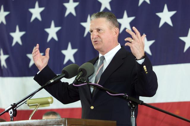 JSC2002-E-14066 (20 April 2002) --- Johnson Space Center’s (JSC) Director Jefferson D. Howell, Jr. speaks from the lectern in Hangar 990 at Ellington Field during the STS-110 crew return ceremonies.