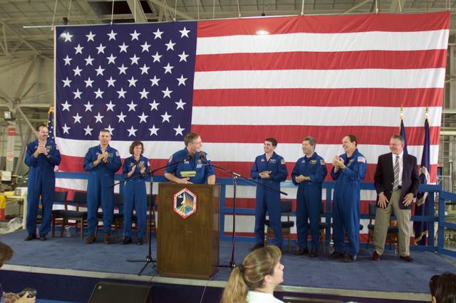 JSC2002-E-14078 (20 April 2002) --- Astronaut Jerry L. Ross, STS-110 mission specialist, speaks from the lectern in Hangar 990 at Ellington Field during the crew return ceremonies. From the left (standing behind Ross) are astronauts Steven L. Smith, Lee M. E. Morin, Ellen Ochoa, Rex J. Walheim, all mission specialists; Stephen N. Frick, pilot; Michael J. Bloomfield, mission commander; and Johnson Space Center&#0146;s (JSC) Director Jefferson D. Howell, Jr.
