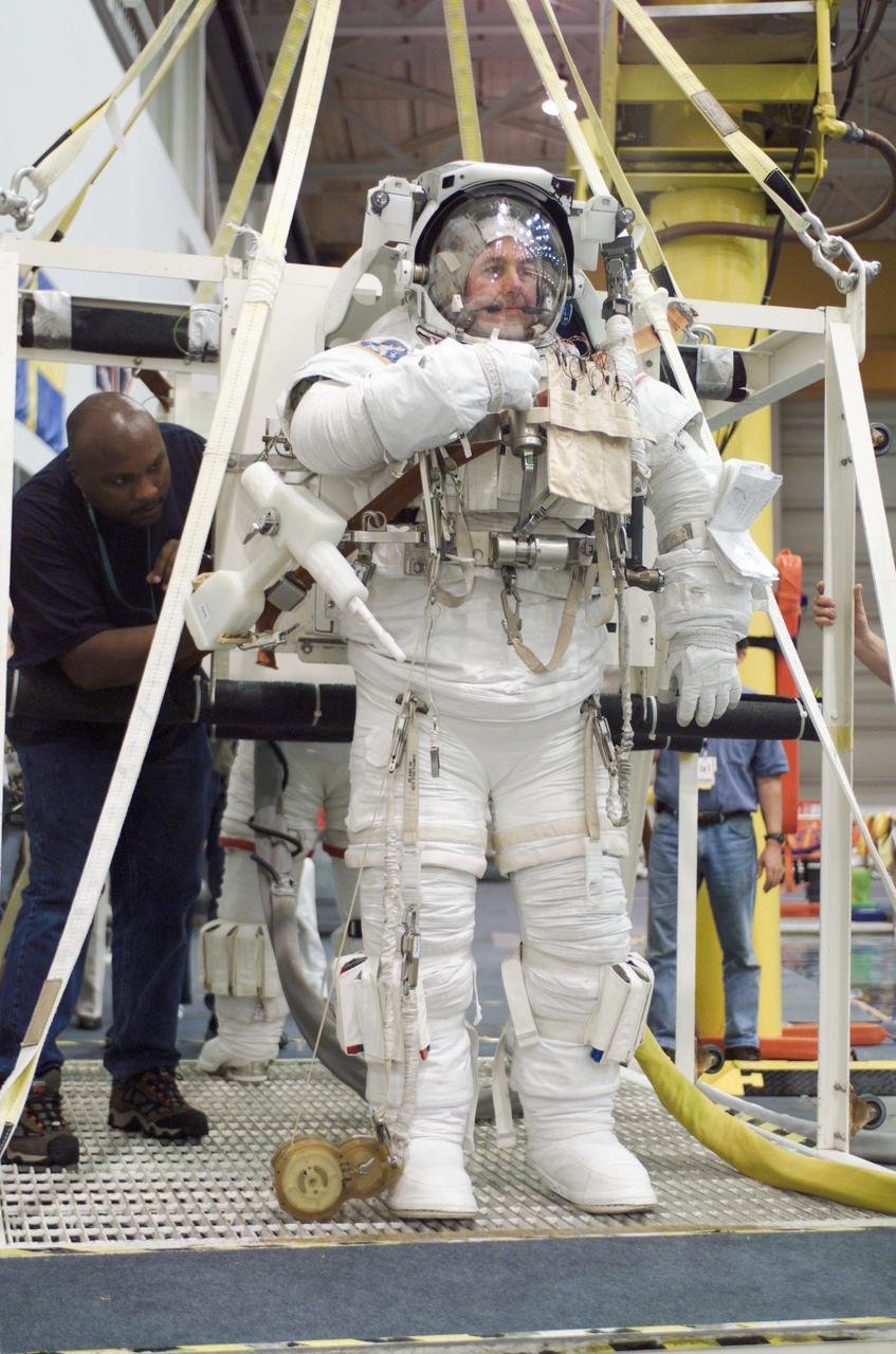 JSC2002-E-23138 (28 May 2002) --- Astronaut Stephen K. Robinson, STS-114 mission specialist, is photographed as the final touches are made on the training version of his Extravehicular Mobility Unit (EMU) spacesuit prior to being submerged in the waters of the Neutral Buoyancy Laboratory (NBL) near the Johnson Space Center (JSC).