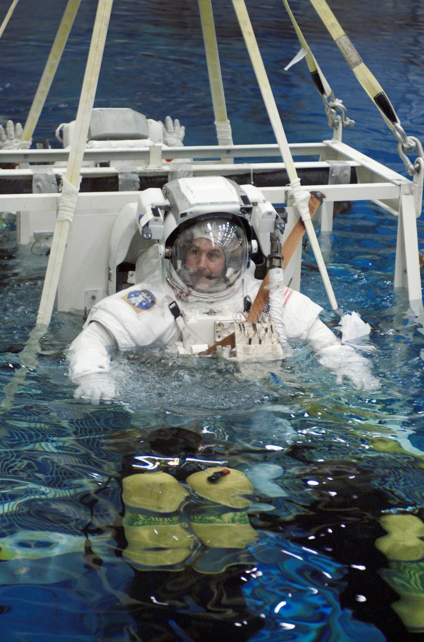 JSC2002-E-23140 (28 May 2002) --- Astronaut Stephen K. Robinson and Soichi Noguchi (partially obscured), both STS-114 mission specialists, are submerged in the waters of the Neutral Buoyancy Laboratory (NBL) at the Johnson Space Center (JSC). Robinson and Noguchi are wearing the training version of the Extravehicular Mobility Unit (EMU) space suit. SCUBA-equipped divers are in the water to assist the astronauts in their rehearsal, intended to help prepare them for work on the exterior of the International Space Station (ISS). Noguchi represents Japan’s National Space Development Agency (NASDA).