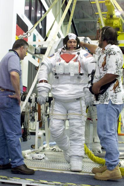 JSC2002-E-27059 (1 July 2002) --- Astronaut Piers J. Sellers, STS-112 mission specialist, attired in a training version of the Extravehicular Mobility Unit (EMU) space suit, is about to be submerged in the waters of the Neutral Buoyancy Laboratory (NBL) near the Johnson Space Center (JSC). Cosmonaut Fyodor N. Yurchikhin (left), mission specialist representing Rosaviakosmos, and United Space Alliance (USA) suit technician Joey Cambiaso assisted Sellers.