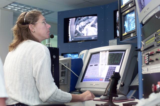 JSC2002-E-27067 (1 July 2002) --- Astronaut Sandra H. Magnus prepares for the STS-112 mission by participating in a hardware-moving simulation. The mission specialist rehearses setting up work for assigned space-walking crewmates in the nearby giant pool of the Neutral Buoyancy Laboratory (NBL) at the Sonny Carter Training  Facility.  Magnus and Expedition Five flight engineer Peggy A. Whitson (already aboard the orbital outpost when this training took place) will be operating the controls of the Space Station Remote Manipulator System (SSRMS or Canadarm2)  during the mission's task of installing the station's S-1 truss.  Astronauts David  A. Wolf and Piers J. Sellers, who would be suited up and standing by in the airlock during this activity, will follow Magnus' set-up work with a space walk.