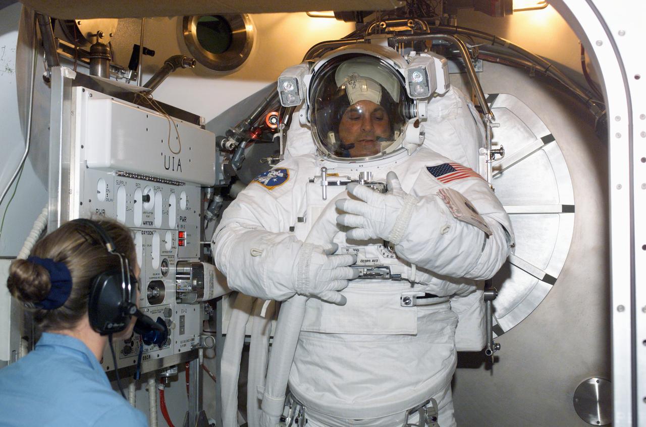 JSC2002-E-27129 (27 June 2002) --- Astronaut David A. Wolf, STS-112 mission specialist, is photographed during an Extravehicular Mobility Unit (EMU) fit check in a Space Station Airlock Test Article (SSATA) in the Crew Systems Laboratory at the Johnson Space Center (JSC).