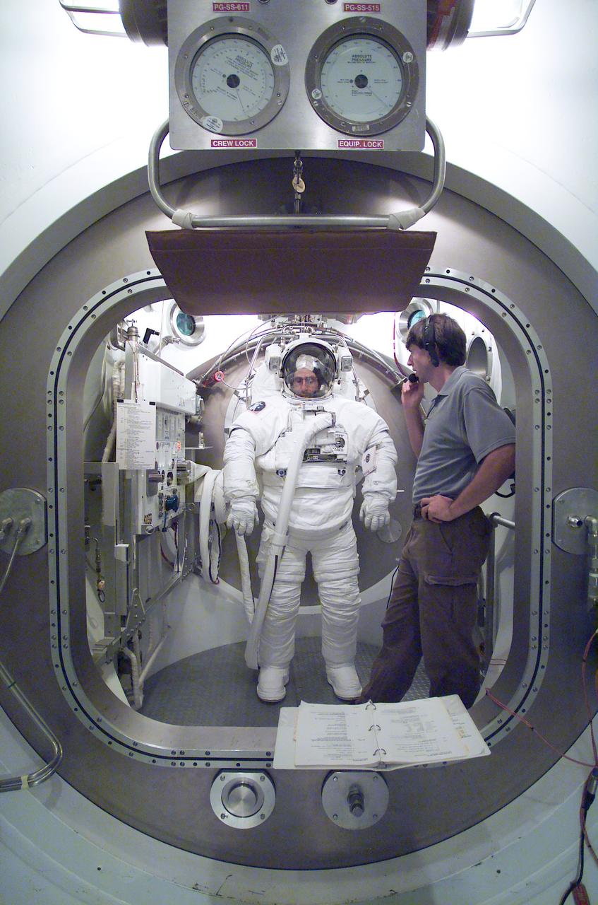 JSC2002-E-36202 (27 August 2002) --- Astronaut Donald R. Pettit, Expedition Six flight engineer, participates in an Extravehicular Mobility Unit (EMU) spacesuit fit check in a Space Station Airlock Test Article (SSATA) in the Crew Systems Laboratory at the Johnson Space Center (JSC). Zebulon L. Scoville assisted Pettit.