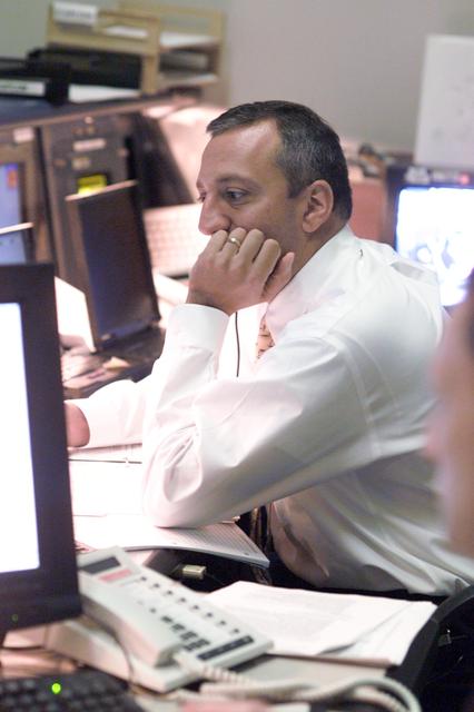 JSC2002-E-47668 (26 November 2002) --- Astronaut Michael J. Massimino, ISS spacecraft communicator (CAPCOM), monitors data at his console in the station flight control room (BFCR) in Houston&#0146;s Mission Control Center (MCC).