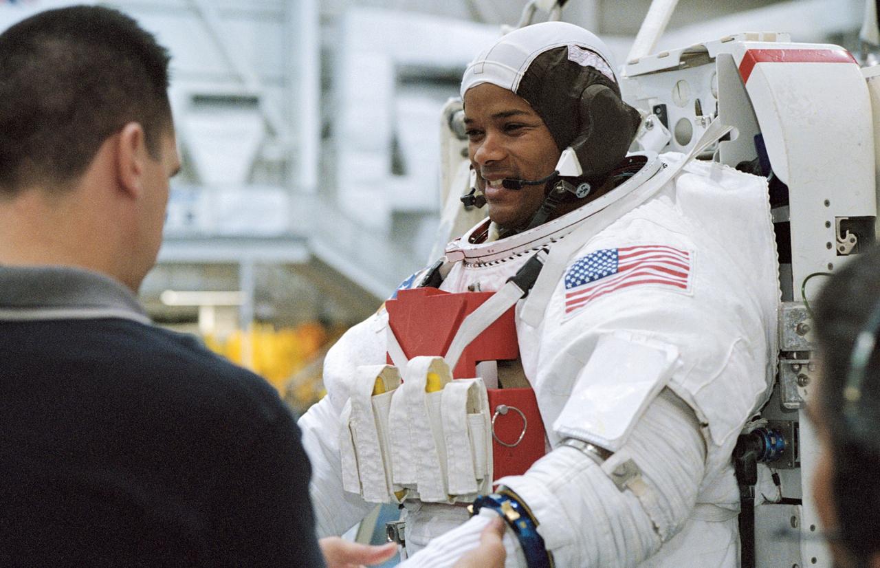 JSC2003-00006 (7 January 2003) --- Astronaut Robert L. Curbeam, Jr., STS-116 mission specialist, gets help with final touches on the training version of his Extravehicular Mobility Unit (EMU) spacesuit prior to being submerged in the waters of the Neutral Buoyancy laboratory (NBL) at the Johnson Space Center (JSC).