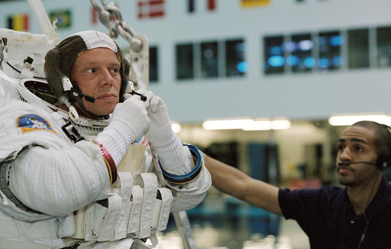 JSC2003-00007 (7 January 2003) --- Astronaut Christer Fuglesang, STS-116 mission specialist, puts the final touches on the training version of his Extravehicular Mobility Unit (EMU) spacesuit prior to being submerged in the waters of the Neutral Buoyancy laboratory (NBL) at the Johnson Space Center (JSC). United Space Alliance (USA) suit technician Jason Rache assisted Fuglesang, who represents the European Space Agency (ESA).