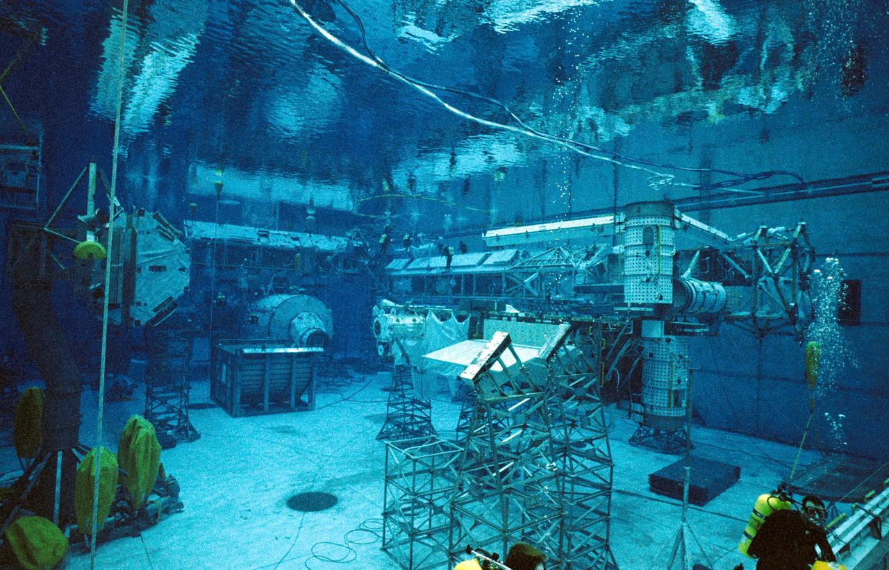 JSC2003-00017 (7 January 2003) --- Astronauts Robert L. Curbeam, Jr. and Christer Fuglesang, STS-116 mission specialists, wearing training versions of the Extravehicular Mobility Unit (EMU) spacesuit, participate in an underwater simulation of extravehicular activity (EVA) scheduled for the 19th shuttle mission to the International Space Station (ISS).  Curbeam and Fuglesang are dwarfed by station truss segments in this overall view of the simulation conducted in the Neutral Buoyancy Laboratory (NBL) near the Johnson Space Center. Fuglesang represents the European Space Agency (ESA).