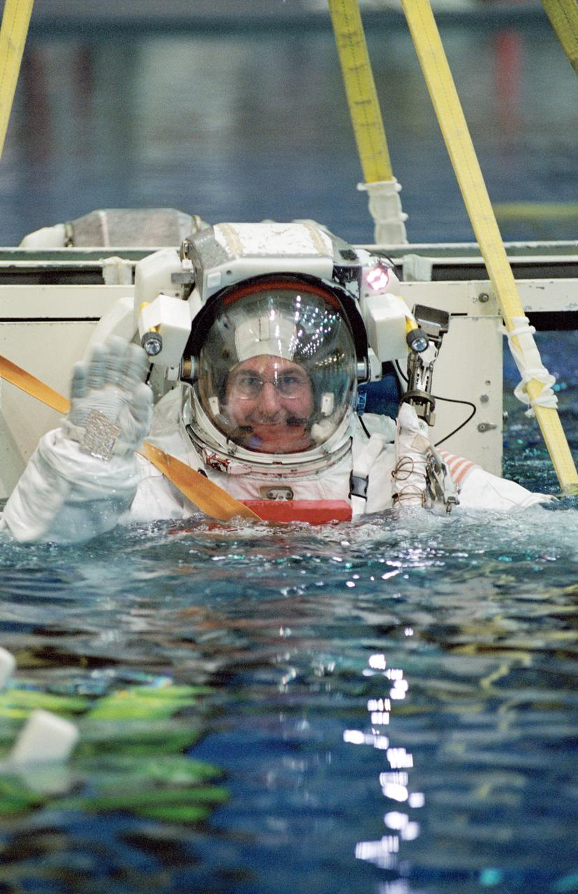 JSC2003-00666 (13 November 2003) --- Astronaut Stephen K. Robinson, STS-114 mission specialist, attired in a training version of the Extravehicular Mobility Unit (EMU) space suit, waves as he is submerged in the waters of the Neutral Buoyancy Laboratory (NBL) near the Johnson Space Center (JSC).