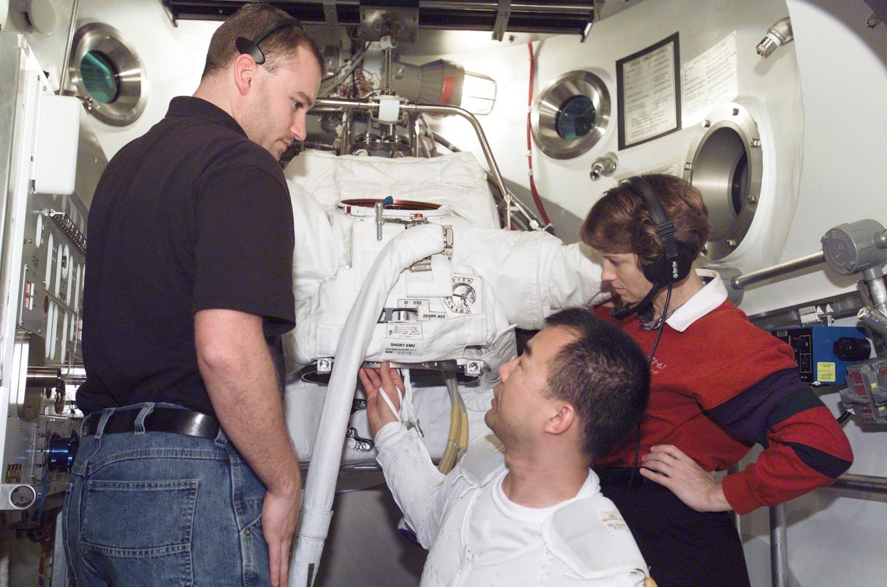 JSC2003-E-01126 (10 January 2003) --- Astronaut Soichi Noguchi (center), STS-114 mission specialist, participates in an Extravehicular Mobility Unit (EMU) spacesuit fit check in the Space Station Airlock Test Article (SSATA) in the Crew Systems Laboratory at the Johnson Space Center (JSC). Astronaut Eileen M. Collins, mission commander, and suit technician Richard S. Kohn with FCE assisted Noguchi, who represents the Japanese Space Agency.
