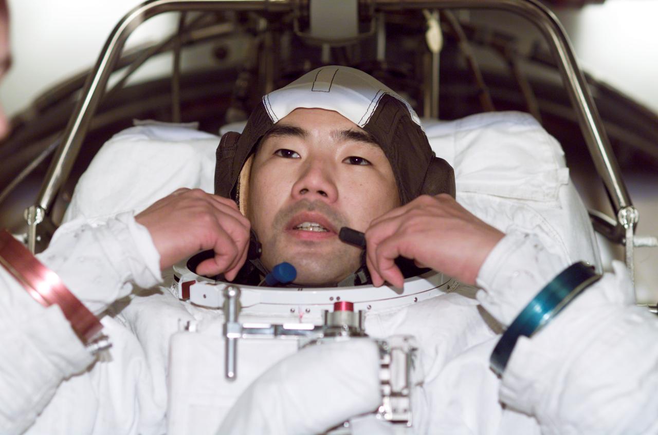 JSC2003-E-01127 (10 January 2003) --- Astronaut Soichi Noguchi, STS-114 mission specialist, participates in an Extravehicular Mobility Unit (EMU) spacesuit fit check in the Space Station Airlock Test Article (SSATA) in the Crew Systems Laboratory at the Johnson Space Center (JSC). Noguchi represents the Japanese Space Agency.