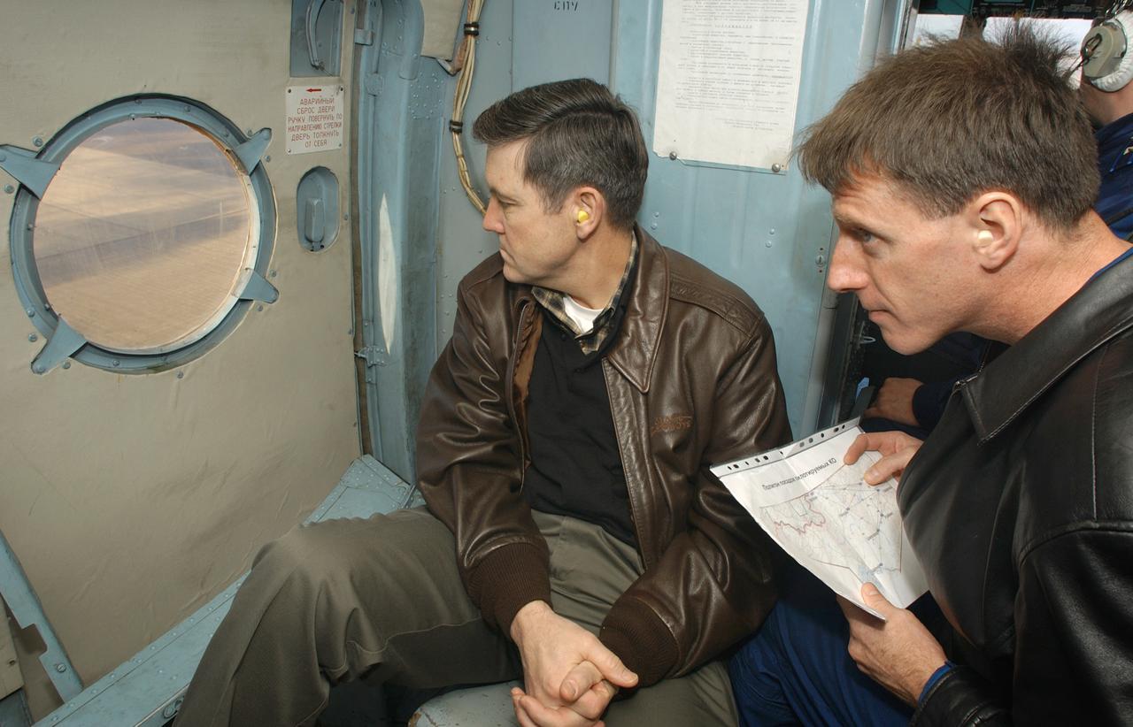 May 4, 2003, Kazakhstan. From the seat of a Russian Helicopter, Bob Cabana (L), Director of Flight Crew Operations and Astronaut Michael Foale (R) look out over the Kazakh terrain for the Expedition Six Soyuz capsule after it's landing in Kazakhstan. Photo Credit: "NASA/Bill Ingalls"