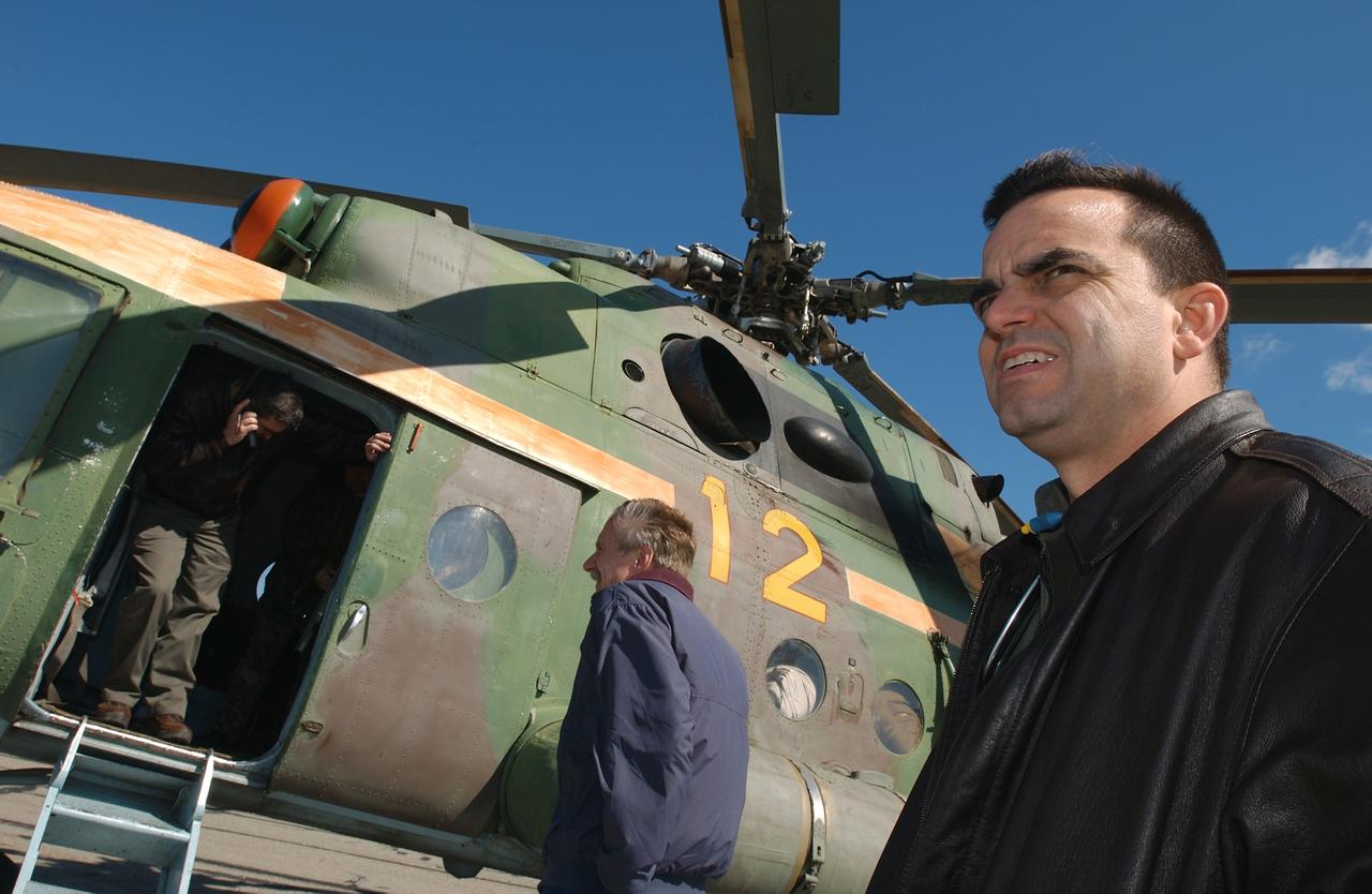 May 4, 2003, Kazakhstan. Bob Cabana (L in door), Director of Flight Crew Operations talks with NASA colleagues on the satellite phone from a Russian helicopter while Bill Gerstenmaier (center), I.S.S. Program Manager and J.D. Polk (R), Expedition Six Flight Surgeon wait to get word if they will be continuing on to the landing site after a refueling stop. Photo Credit: "NASA/Bill Ingalls"
