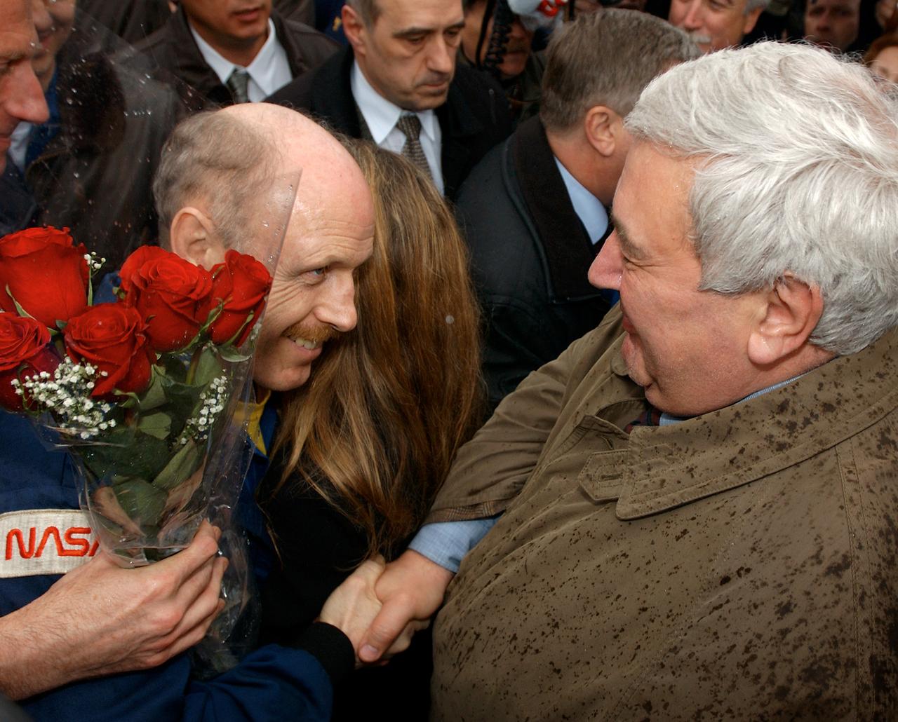 May 4, 2003, Star City, Russia. Russian Space Agency Director Yuri Koptev shakes hands with Expedition Six Commander Ken Bowersox, as bowersox is also hugged by his wife Annie. Photo Credit: "NASA/Bill Ingalls"