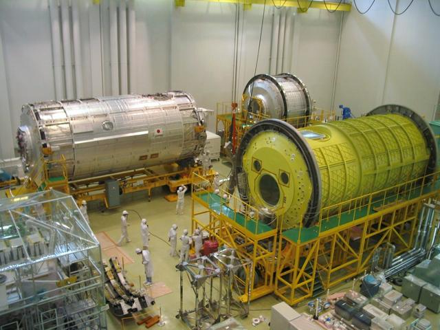 JSC2003-E-34753 (16 April 2003) --- Components of Japan's primary contribution to the International Space Station, the Japanese Experiment Module (JEM), Kibo, are seen in this view at the Tsukuba Space Center.  Clockwise from left are the JEM Pressurized Module (PM) (an on-orbit laboratory), the JEM Experiment Logistics Module - Pressurized Section (an experiment and logistics storage module), the JEM PM Engineering Model (used for pre-flight development and testing), and the JEM Exposed Facility (an unpressurized platform for space environment experiments).  The laboratory module was transported by truck and then by barge to Yokohama Harbor, Yokohama, Japan where it was loaded on a container ship bound for Port Canaveral, Florida. The Kibo laboratory, built by the National Space Development Agency of Japan (NASDA), is expected to arrive at the Kennedy Space Center for module integration tests with Node 2 and pre-launch processing in early June.  Photo Credit: NASA