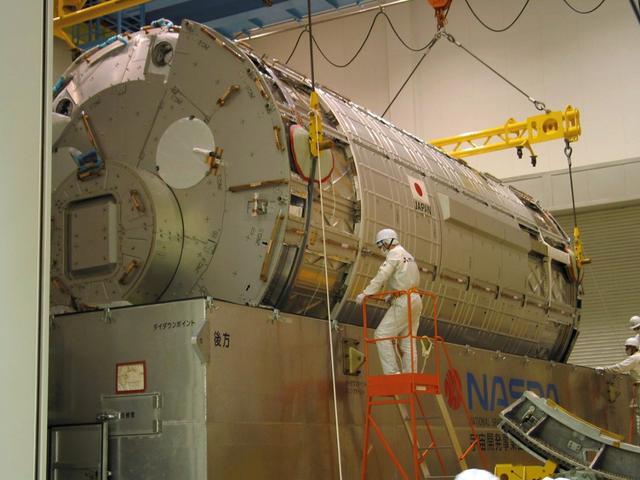 JSC2003-E-34758 (16 April 2003) --- The Kibo Japanese Experiment Module's (JEM) Pressurized Module, a science laboratory bound for the International Space Station, is lowered into a shipping crate, in preparation for shipment to the Kennedy Space Center where it will be prepared for launch aboard the Space Shuttle. A container transport ship carrying Kibo left Yokohama Harbor, Japan, May 2, 2003, bound for Port Canaveral, Florida, where it is expected to arrive in early June. It will then be transported to KSC's Space Station Processing Facility.