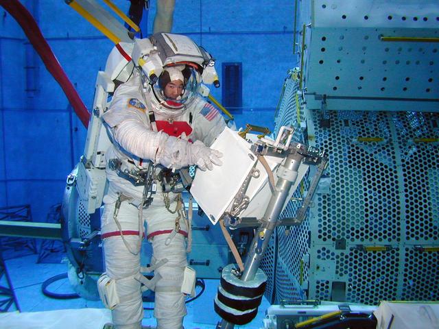 JSC2004-E-13023 (2 March 2004) --- Japanese Aerospace and Exploration Agency (JAXA) Astronaut Soichi Noguchi, the lead space walker for the Space Shuttle's return to flight on mission STS-114, checks a potential repair technique for the Shuttle's heat protection tiles in Johnson Space Center's (JSC) Neutral Buoyancy Laboratory (NBL) pool. The checkout session was conducted on March 2, 2004, and checked the latest techniques and hardware under development for Noguchi to use during an in-flight test of new Shuttle heat shield repair possibilities during STS-114. The mission is now targeted for launch no earlier than the spring of 2005.
