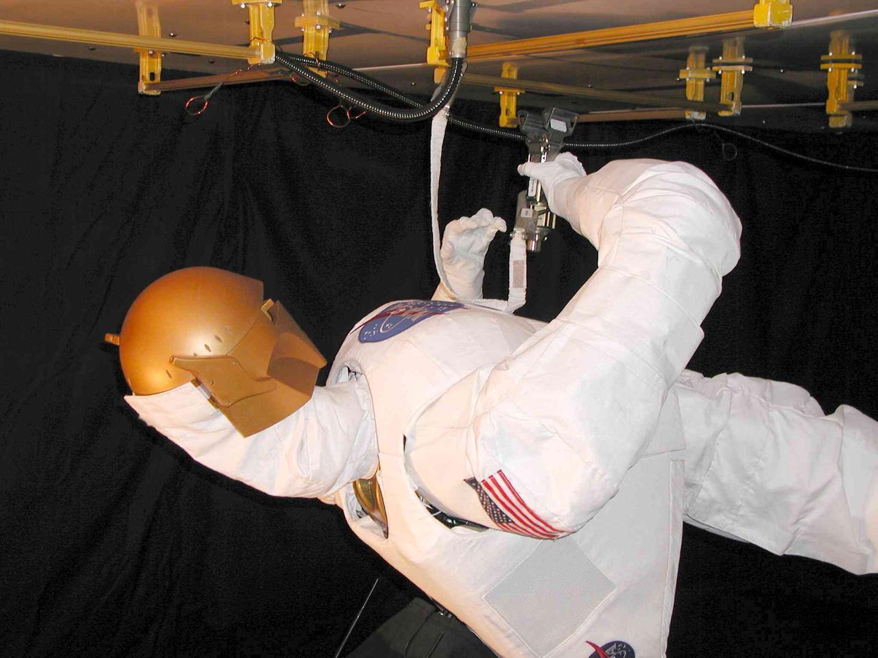 JSC2004-E-16341 (March 2004) --- Robonaut uses a standard human spacewalk tether to connect itself to an International Space Station (ISS) exterior handrail on the test panel. The Robonaut Project is a collaborative effort with the Defense Advanced Research Projects Agency (DARPA), and has been under development at Johnson Space Center (JSC) for several years.