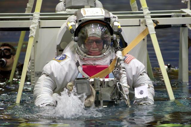 JSC2004-E-27324 (30 June 2004) --- Astronaut John L. Phillips, Expedition 11 NASA ISS science officer, and cosmonaut Sergei K. Krikalev (partially obscured), commander representing Russia’s Federal Space Agency, are submerged in the waters of the Neutral Buoyancy Laboratory (NBL) near Johnson Space Center (JSC). Phillips and Krikalev are wearing training versions of the Extravehicular Mobility Unit (EMU) space suit. Divers are in the water to assist the crewmembers in their rehearsal, intended to help prepare them for work on the exterior of the International Space Station (ISS).