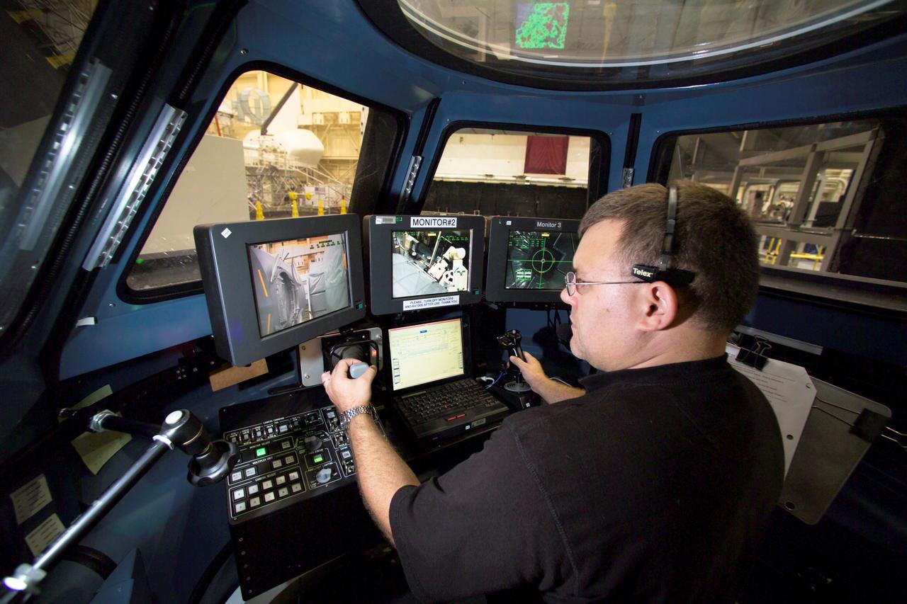 JSC2004-E-44629 (7 Oct. 2004) --- Paul Williamson, crew instructor, operates a simulated version of the International Space Station robotic arm, Canadarm2, in the Multi-use Remote Manipulator Development Facility at the Johnson Space Center. A robotic control station for operating the arm is setup in a mockup of the Cupola module where arm operations will be housed in the future on Station. The Cupola, a dome-shaped module with seven windows, will give astronauts a panoramic view for observing many operations on the outside of the orbiting complex. Today, Station crews use a robotic control computer station located in the Destiny Laboratory to operate the arm. The Cupola is scheduled to be installed on Station in early 2009 and one of the robotic control stations will be permanently placed inside.