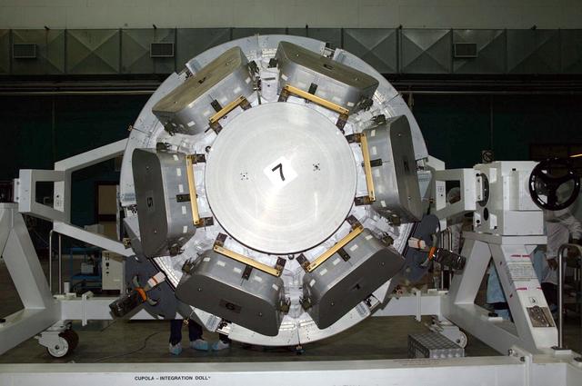 JSC2004-E-44649 (September 2004) --- Engineers and technicians (partially visible in right background) check the International Space Station's Cupola in the Alenia Spazio clean room in Turin, Italy. Personnel are preparing the hardware for shipment to NASA's launch facility at Cape Kennedy, Florida.  From inside the Cupola, a dome-shaped module with seven windows, astronauts have a panoramic view for observing operations on the outside of the orbiting complex. The Cupola module provides external observation capabilities during spacewalks, docking operations, hardware surveys and for Earth and celestial studies. It also serves as the primary location for executing robot arm operations of Canadarm2. Until the Cupola is installed, crews have been using a robotic control computer station located in the Destiny Laboratory to operate the arm. The Cupola&#0146;s windows enhance the robotic arm operator's situational awareness, supplementing camera and graphic views provided by the computer workstation. Photo Credit: Alenia Spazio