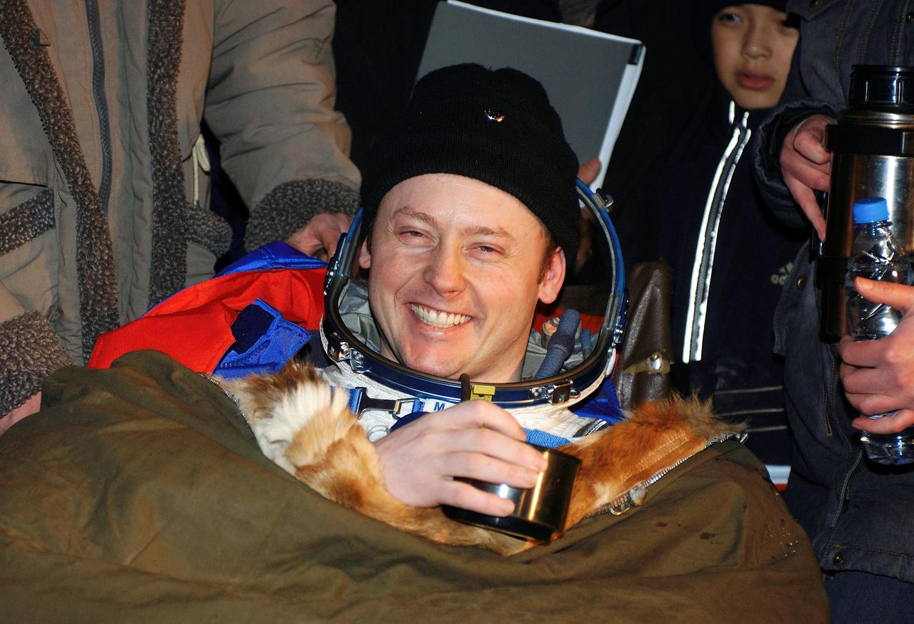 JSC2004-E-47550 (24 October 2004) --- Astronaut Edward M. (Mike) Fincke, NASA International Space Station (ISS) science officer and flight engineer, shows his happiness with the successful landing in the Soyuz spacecraft with fellow crew members cosmonaut Gennady I. Padalka, Russia&#0146;s Federal Space Agency Expedition 9 commander, and Russian Space Forces cosmonaut Yuri Shargin. The crew landed approximately 85 kilometers northeast of Arkalyk in northern Kazakhstan on October 24, 2004.  Photo Credit: "NASA/Bill Ingalls"