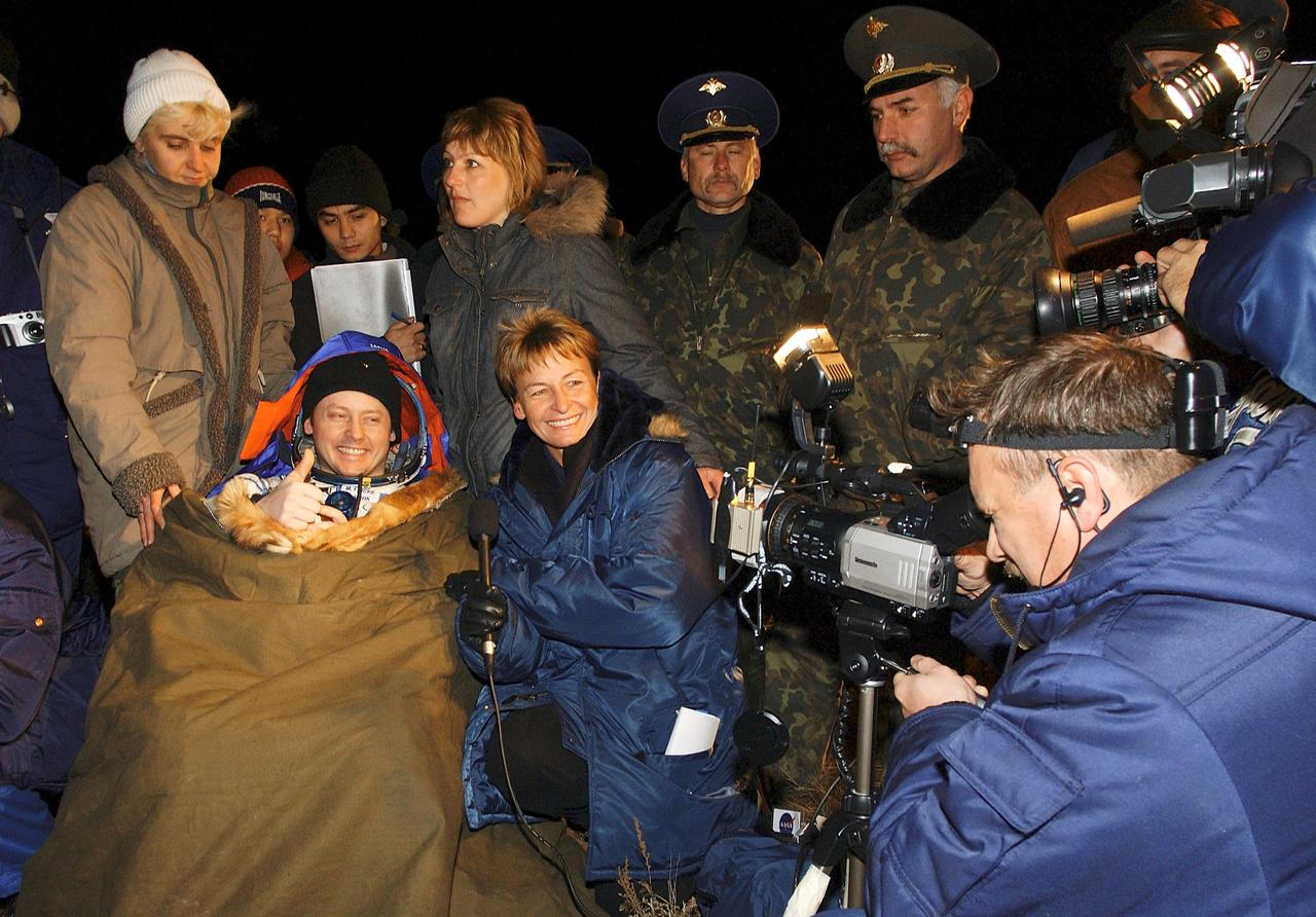 JSC2004-E-47551 (24 October 2004) --- Astronaut Edward M. (Mike) Fincke, NASA International Space Station (ISS) science officer and flight engineer, is interviewed for the video phone by astronaut Peggy Whitson, Expedition 5 flight engineer, after the successful landing in the Soyuz spacecraft with fellow crew members cosmonaut Gennady I. Padalka, Russia’s Federal Space Agency Expedition 9 commander, and Russian Space Forces cosmonaut Yuri Shargin. The crew landed approximately 85 kilometers northeast of Arkalyk in northern Kazakhstan on October 24, 2004. Photo Credit: "NASA/Bill Ingalls"