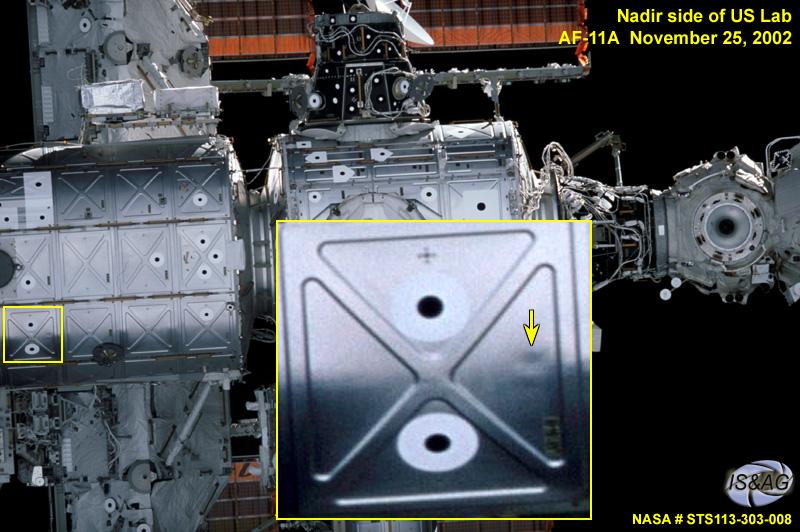 JSC2004-E-50470 (25 November 2002) --- The original photograph in this image was taken during the Space Shuttle Endeavour&#0146;s approach to the International Space Station for docking during the STS-113/11A assembly mission. An indentation in a micrometeoroid debris panel on the exterior of the Destiny Laboratory module is indicated by an arrow in an enhanced section of the image provided by the Image Science and Analysis Group at the Johnson Space Center. Analysis of this image and additional video indicates that the indentation is not from a debris strike, but is consistent with flat spots seen on other areas that are likely the result of significant temperature changes. The protective shield&#0146;s function is not affected by the indentations.