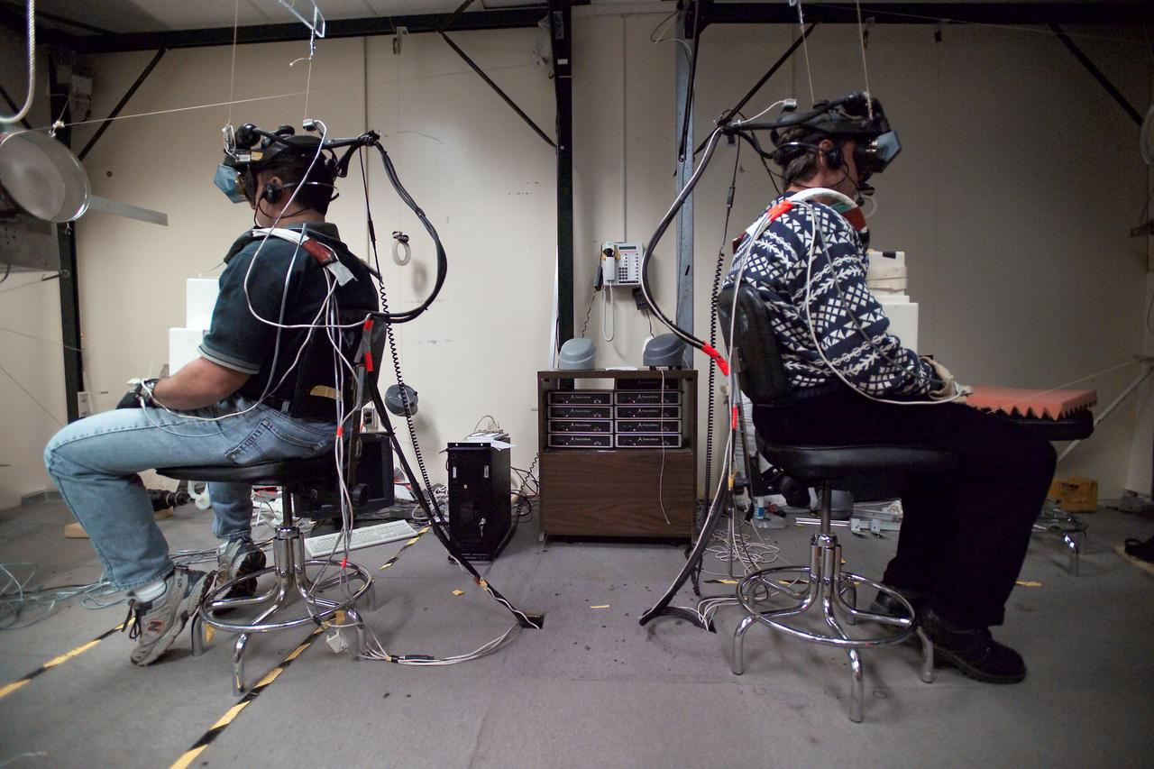 JSC2005-E-04515 (3 Feb. 2005) --- Astronauts Nicholas J.M. Patrick (left) and European Space Agency (ESA) astronaut Christer Fuglesang, both STS-116 mission specialists, use virtual reality hardware in the Space Vehicle Mockup Facility at the Johnson Space Center to rehearse some of their duties on the upcoming mission to the international space station. This type of virtual reality training allows the astronauts to wear a helmet and special gloves while looking at computer displays simulating actual movements around the various locations on the station hardware with which they will be working.