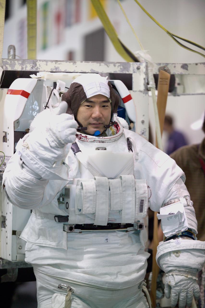 JSC2005-E-07617 (24 February 2005) --- Astronaut Soichi Noguchi, STS-114 mission specialist representing Japan Aerospace Exploration Agency (JAXA), attired in a training version of the Extravehicular Mobility Unit (EMU) spacesuit, gives a ;thumbs up; signal prior to being submerged in the waters of the Neutral Buoyancy Laboratory (NBL) near Johnson Space Center. This training session occurred during STS-114 Media Day at the NBL.