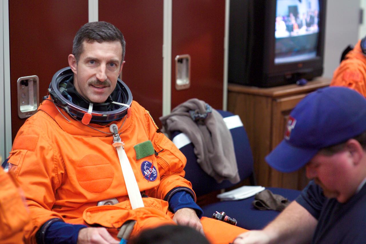 JSC2005-E-13774 (5 April 2005) --- Astronaut Daniel C. Burbank, STS-115 mission specialist, dons a training version of the shuttle launch and entry suit prior to the start of an emergency egress training session in the Space Vehicle Mockup Facility at the Johnson Space Center. Suit technician Mike Thompson assisted Burbank.