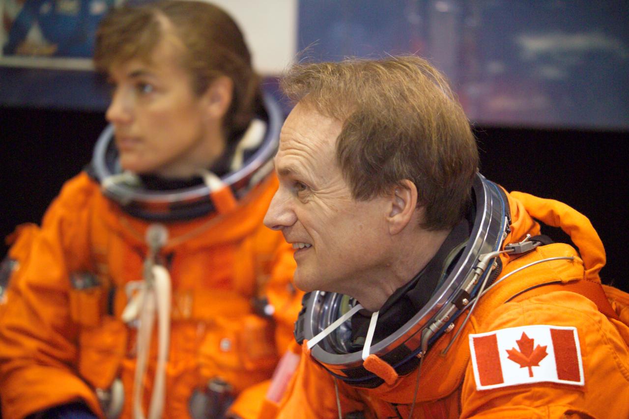 JSC2005-E-13817 (5 April 2005) --- Astronaut Steven G. MacLean, STS-115 mission specialist representing the Canadian Space Agency, attired in a training version of the shuttle launch and entry suit, awaits the start of an emergency egress training session in the Space Vehicle Mockup Facility at the Johnson Space Center. Astronaut Heidemarie M. Stefanyshyn-Piper, mission specialist, is visible in the background.