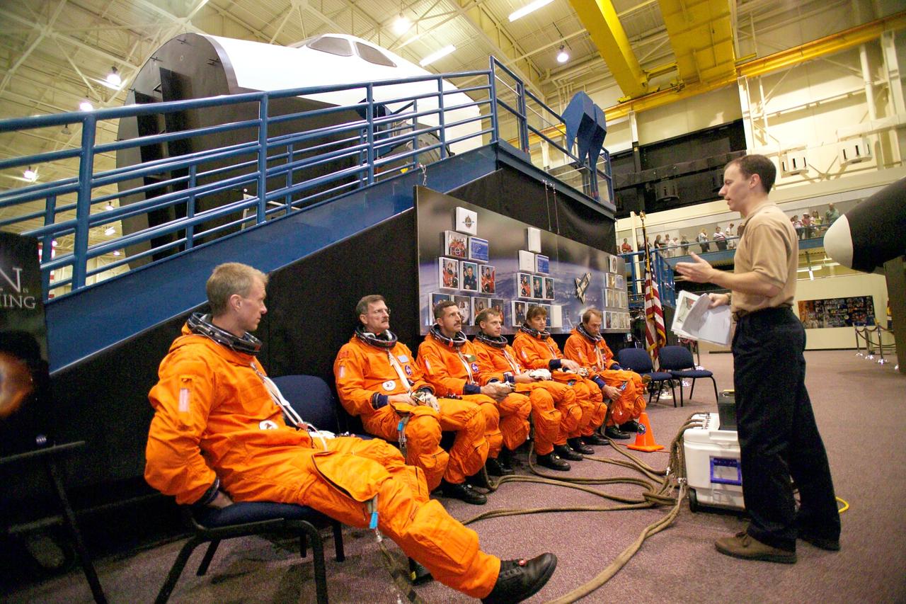 JSC2005-E-17421 (28 April 2005) --- Crew trainer David Pogue (right) briefs STS-115 crewmembers during an emergency egress training session in the Space Vehicle Mockup Facility at Johnson Space Center. From the left are astronauts Brent W. Jett Jr., commander; Joseph R. (Joe) Tanner and Daniel C. Burbank, both mission specialists; Christopher J. Ferguson, pilot; Heidemarie M. Stefanyshyn-Piper, mission specialist; and Steven G. MacLean, mission specialist representing the Canadian Space Agency.