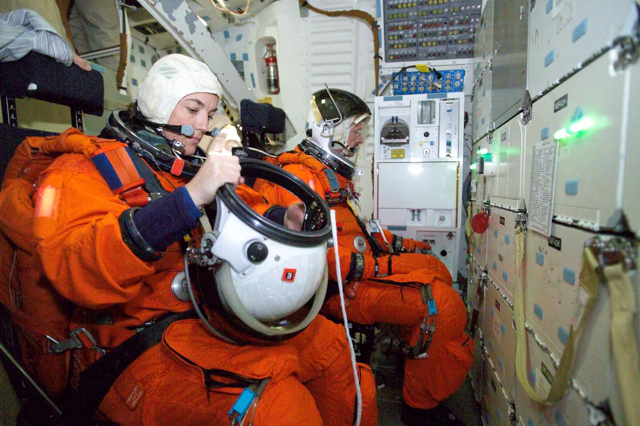 JSC2005-E-17437 (28 April 2005) --- Astronauts Heidemarie M. Stefanyshyn-Piper (foreground) and Joseph R. (Joe) Tanner, both STS-115 mission specialists, participate in a training session in one of the full-scale trainers in the Space Vehicle Mockup Facility at the Johnson Space Center. Attired in training versions of the shuttle launch and entry suit, the two are seated on the middeck for an emergency egress training session.