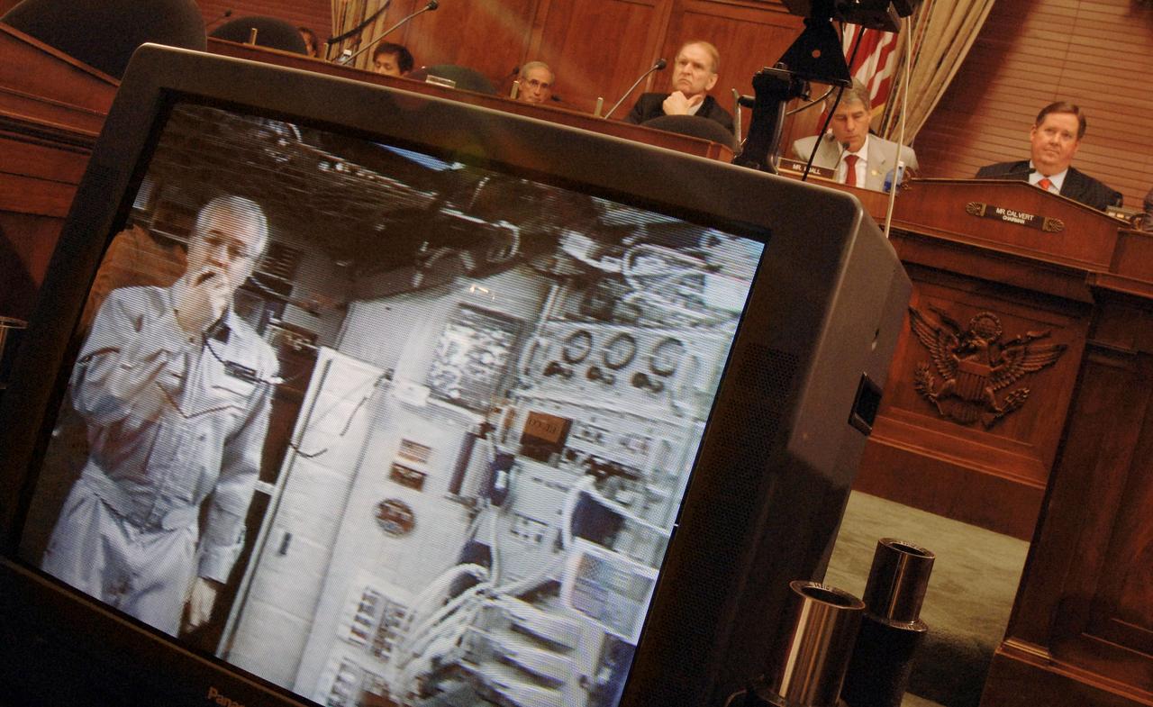 JSC2005-E-22364 (14 June 2005) --- Astronaut John L. Phillips, Expedition 11 NASA ISS science officer and flight engineer, testifies via video screen before the House Subcommittee on Space and Aeronautics chaired by Rep. Ken Calvert (R-Calif.), as he orbited Earth onboard the International Space Station (ISS) at a speed of five miles a second. Phillips was approximately 220 statute miles above Earth, but his radio transmissions were routed to a Tracking and Data Relay Satellite (TDRS) in geostationary orbit at an altitude of about 22,300 miles. Photo credit: NASA/Bill Ingalls.