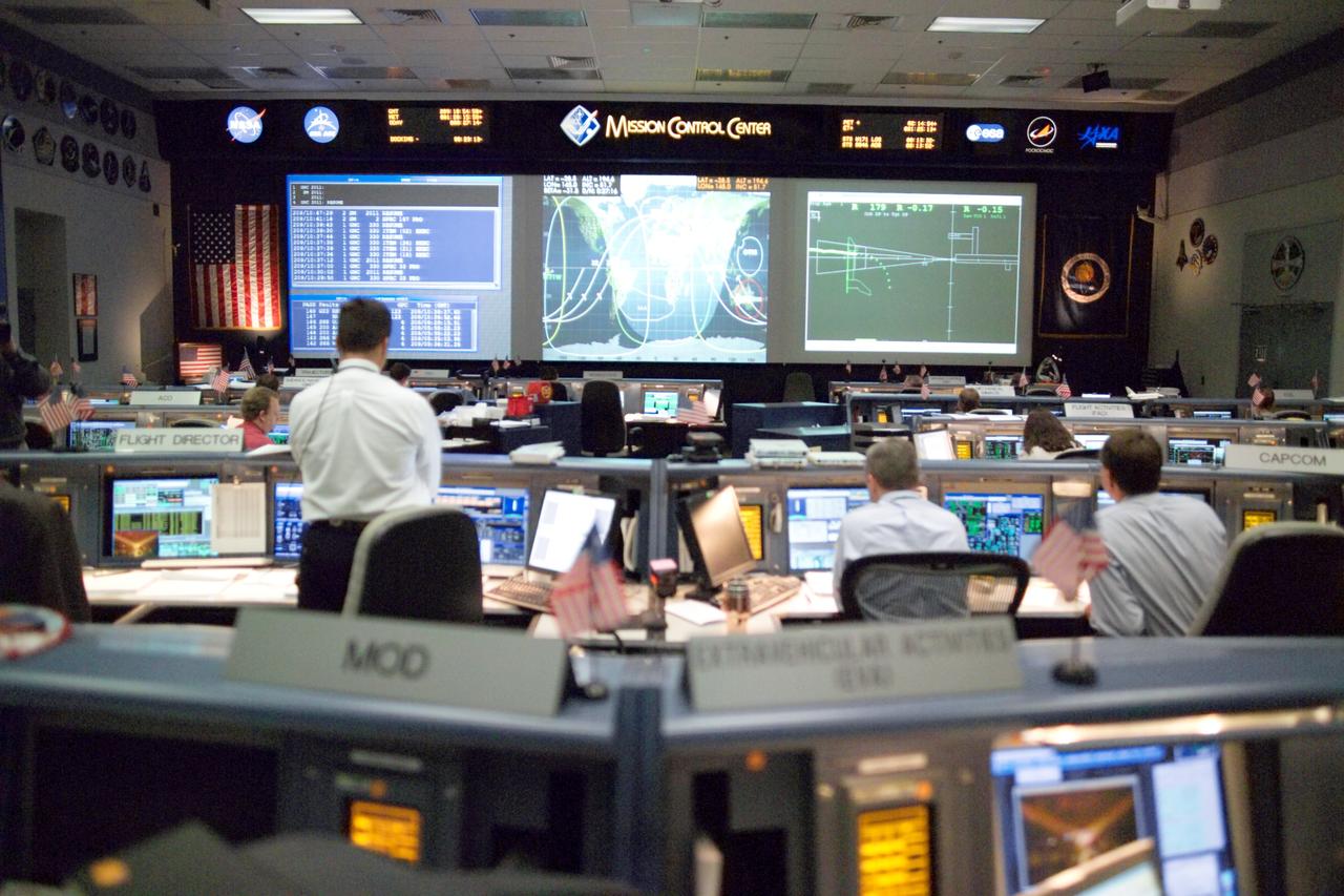 JSC2005-E-30649 (28 July 2005) --- In this wide shot of the Space Shuttle (White) Control Room, STS-114 Lead Flight Director Paul Hill stands at his console during the very busy rendezvous and docking activities between the Discovery and International Space Station.