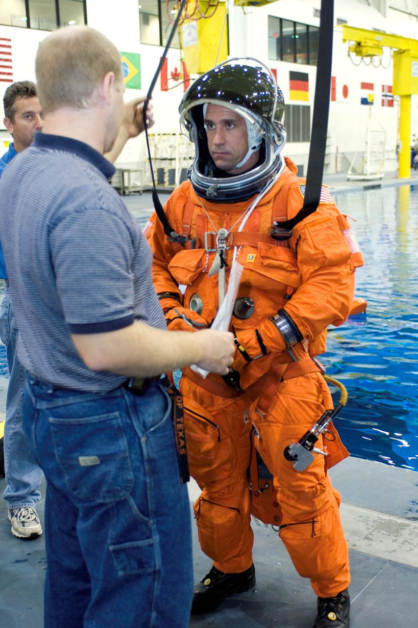 JSC2005-E-31220 (28 July 2005) --- Crew trainer Bob Behrendsen briefs astronaut William A. Oefelein, STS-116 pilot, in the usage of parachute gear during an emergency egress training session in the Neutral Buoyancy Laboratory (NBL) near Johnson Space Center. Oefelein is wearing a training version of the shuttle launch and entry suit.