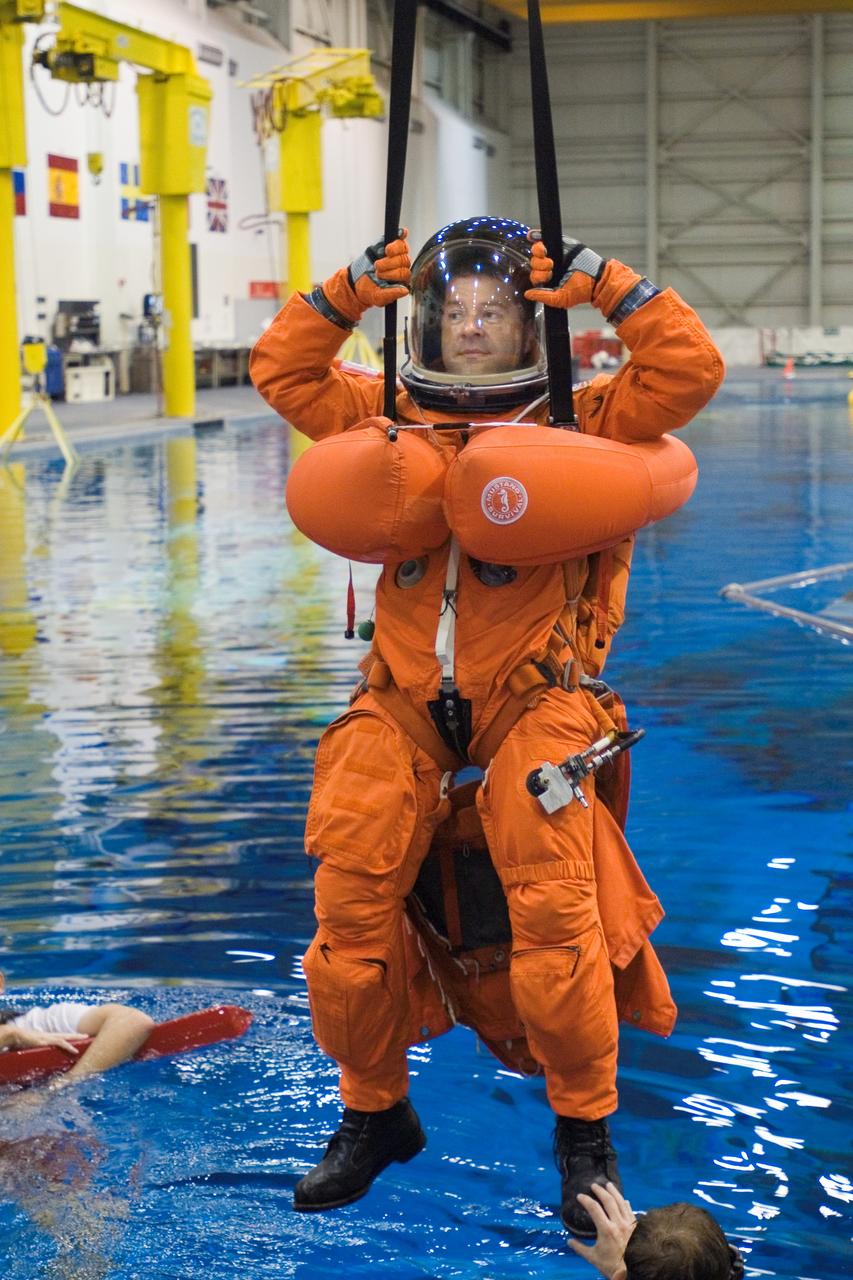 JSC2005-E-31280 (28 July 2005) --- Astronaut Nicholas J. M. Patrick, STS-116 mission specialist, attired in a training version of the shuttle launch and entry suit, simulates a parachute drop into water during an emergency bailout training session at the Neutral Buoyancy Laboratory (NBL) near the Johnson Space Center.
