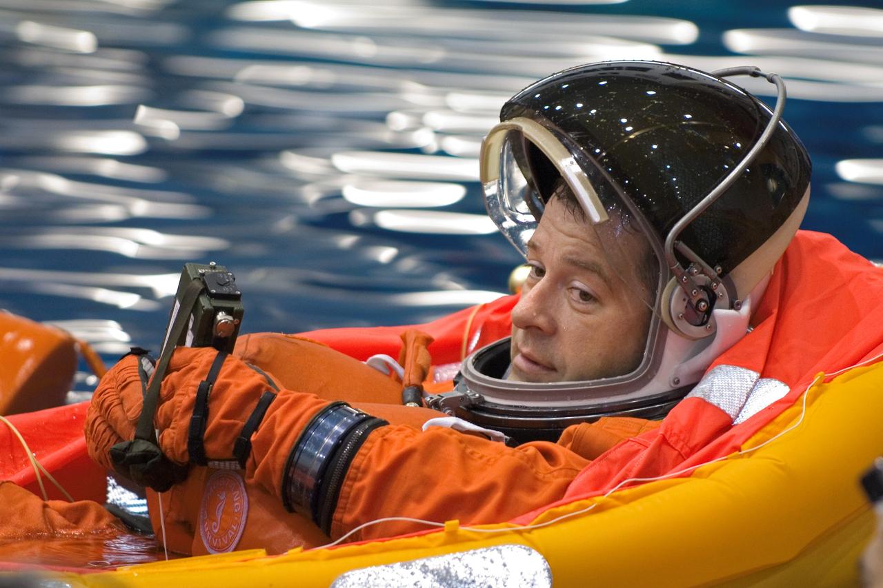 JSC2005-E-31291 (28 July 2005) --- Astronaut Nicholas J. M. Patrick, STS-116 mission specialist, attired in a training version of the shuttle launch and entry suit, floats in a small life raft during an emergency egress training session in the Neutral Buoyancy Laboratory (NBL) near the Johnson Space Center.