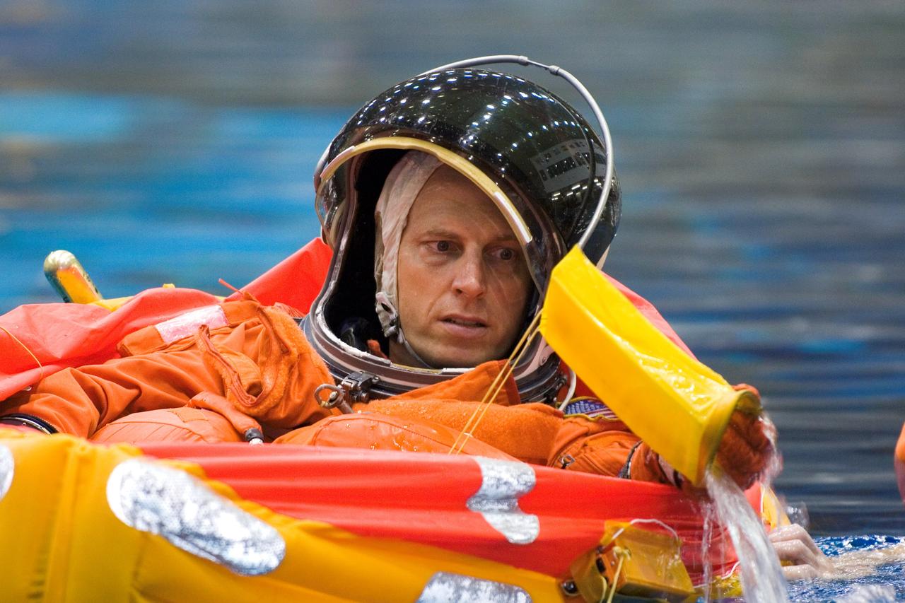 JSC2005-E-31315 (28 July 2005) --- Astronaut Clayton C. Anderson, Expedition 14 backup flight engineer, floats in a small life raft during an emergency bailout training session in the Neutral Buoyancy Laboratory (NBL) near the Johnson Space Center. Anderson is wearing a training version of the shuttle launch and entry suit.