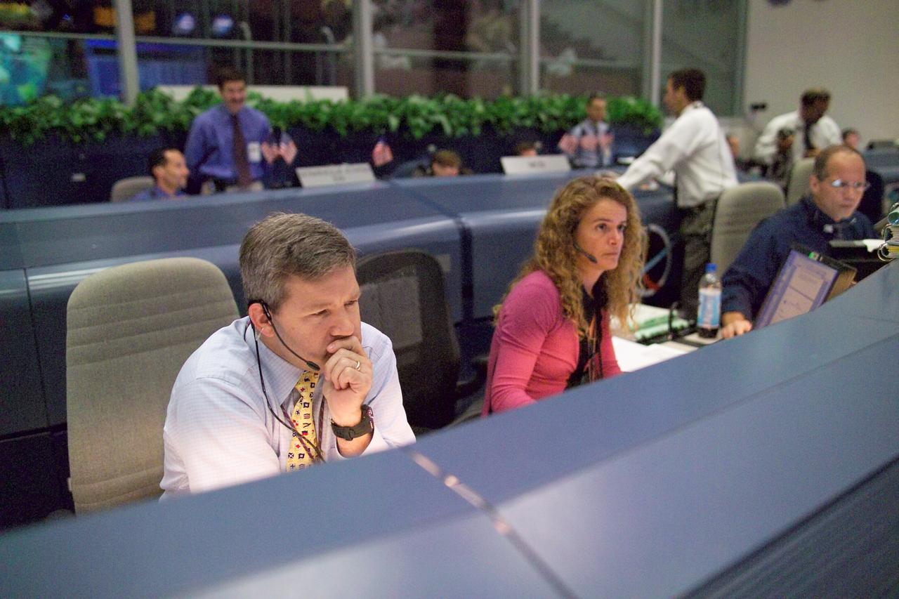 JSC2005-E-31936 (3 August 2005) --- Astronauts Julie Payette (Canadian Space Agency) and Stephen N. Frick monitor communications at the spacecraft communicator (CAPCOM) console in the Shuttle (White) Flight Control Room in Johnson Space Center&#0146;s (JSC) Mission Control Center during the third period of extravehicular activity (EVA) for STS-114.