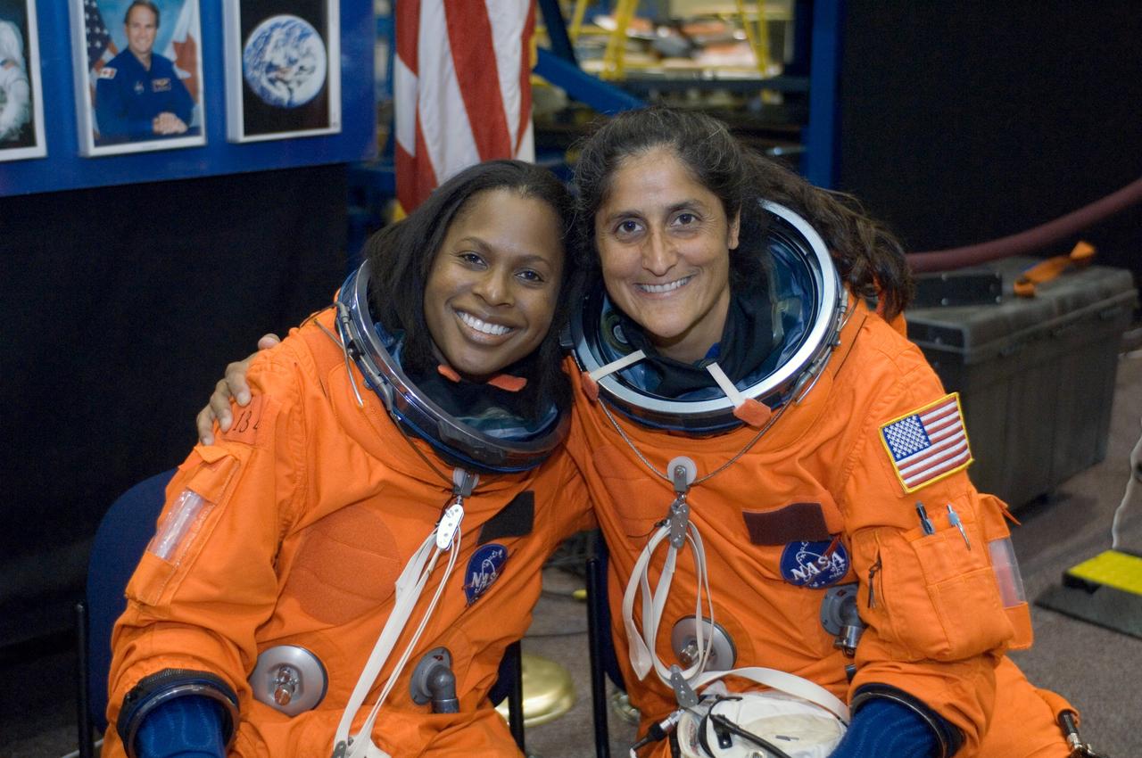 JSC2005-E-32704 (1 Aug. 2005) --- Astronauts Joan E. Higginbotham (left), STS-116 mission specialist, and Sunita L. Williams, Expedition 14 flight engineer, attired in training versions of the shuttle launch and entry suit, pose for a photo as they await the start of an emergency egress training session in the Space Vehicle Mockup Facility at the Johnson Space Center. Williams will join Expedition 14 in progress and serve as a flight engineer after traveling to the station on space shuttle mission STS-116.