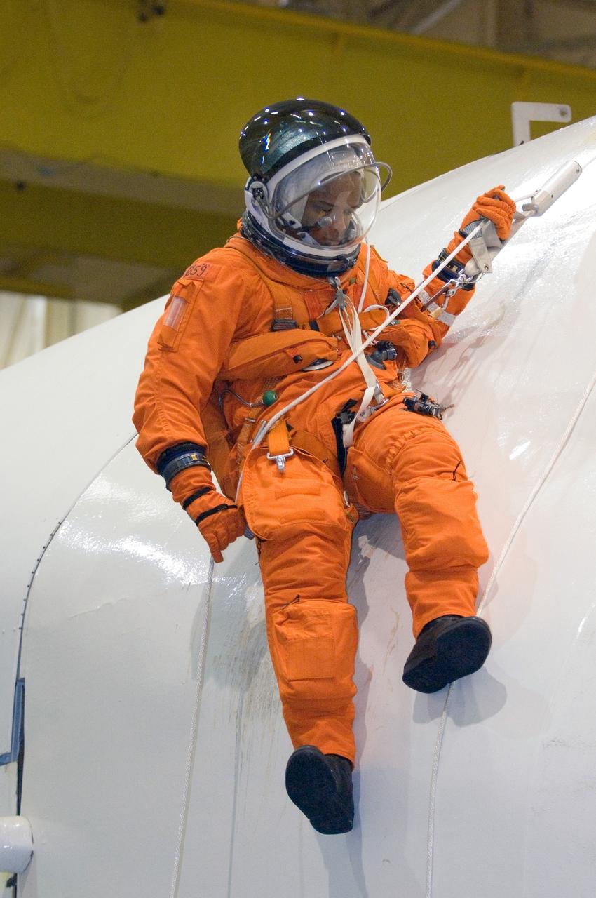JSC2005-E-32763 (1 Aug. 2005) --- Astronaut Robert L. Curbeam, STS-116 mission specialist, uses a special pulley device to escape from a simulated trouble-plagued shuttle during a session of egress training in the Space Vehicle Mockup Facility at Johnson Space Center. The full fuselage trainer (FFT) is a full-scale mockup of a shuttle. Curbeam is wearing a training version of the shuttle launch and entry suit.