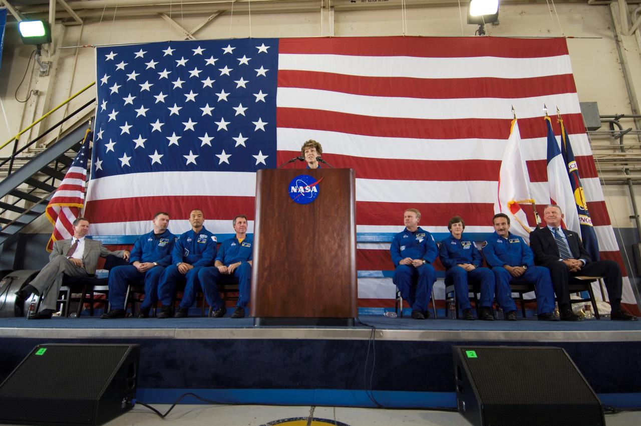 JSC2005-E-33333 (10 August 2005) --- Astronaut Eileen M. Collins, STS-114 commander, speaks from a lectern in Ellington Field&#0146;s Hangar 276 near Johnson Space Center (JSC) during the STS-114 crew return ceremonies. Seated from the left are NASA Administrator Michael Griffin; astronauts James M. Kelly, pilot; Soichi Noguchi, mission specialist representing Japan Aerospace Exploration Agency (JAXA); Stephen K. Robinson, Andrew S. W. Thomas, Wendy B. Lawrence, Charles J. Camarda, mission specialists; and JSC Director General Jefferson D. Howell, Jr.