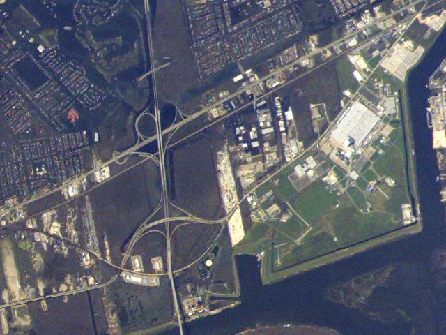 JSC2005-E-37991 (8 September 2005) ---  NASA Michoud Test Facility is located at right center of this image acquired from the International Space Station on September 8, 2005. While the facility itself is largely dry, the adjacent neighborhoods are extensively flooded (dark greenish brown regions to the left and right of I-510, left of image center); portions of the highway cloverleaf are also inundated. Image is cropped from the parent frame, ISS011-E-12527 and is oriented with north to the top.