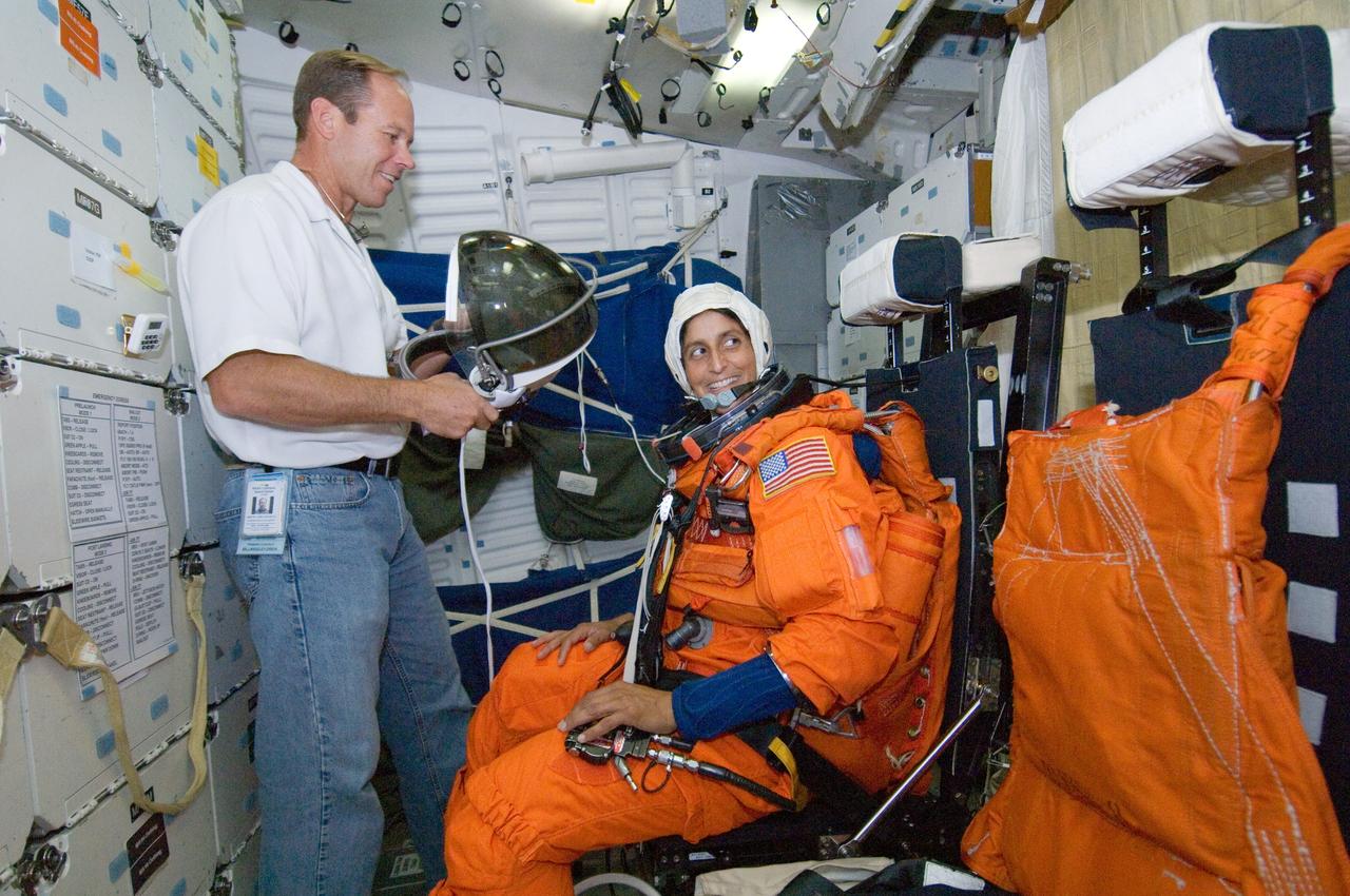 JSC2005-E-39940 (20 Sept. 2005) --- Astronaut Sunita L. Williams, Expedition 14 flight engineer, participates in a mission training session in one of the high fidelity trainers/mockups in the Space Vehicle Mockup Facility at Johnson Space Center. Williams, attired in a training version of the shuttle launch and entry suit, is seated on the middeck for an emergency egress training session. Williams will join Expedition 14 in progress and serve as a flight engineer after traveling to the station on space shuttle mission STS-116. United Space Alliance (USA) suit technician Drew Billingsley assisted Williams.